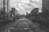 城市街景中，有轨电车线路穿梭于单色摩天大楼之间