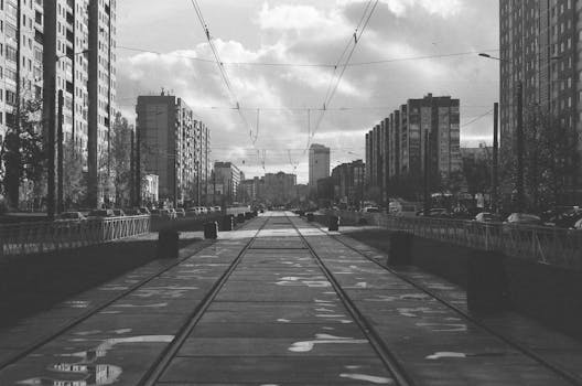 城市街景中，有轨电车线路穿梭于单色摩天大楼之间