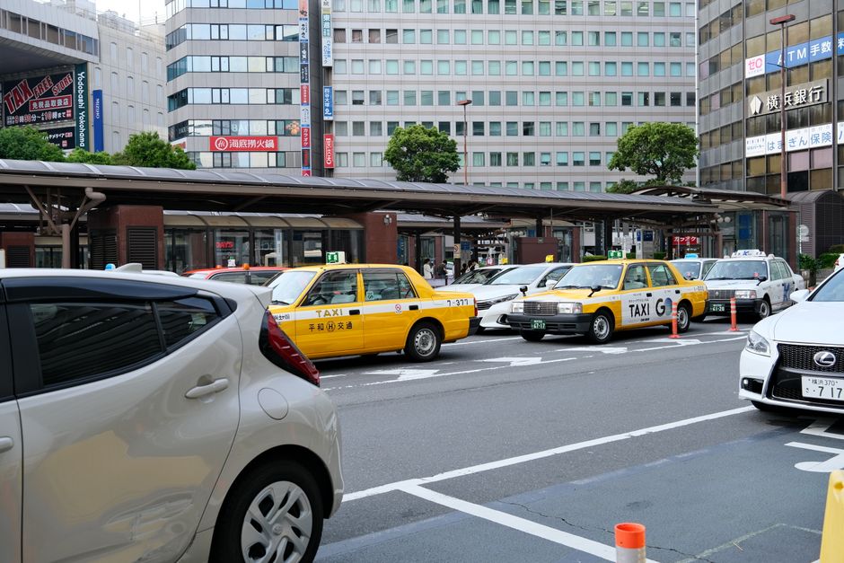 横浜、日本の黄色いタクシーと現代的な建物の都市風景。