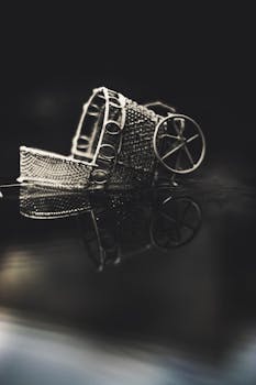 经典的复古银色微型婴儿车倒映在光滑的表面上，细节尽显