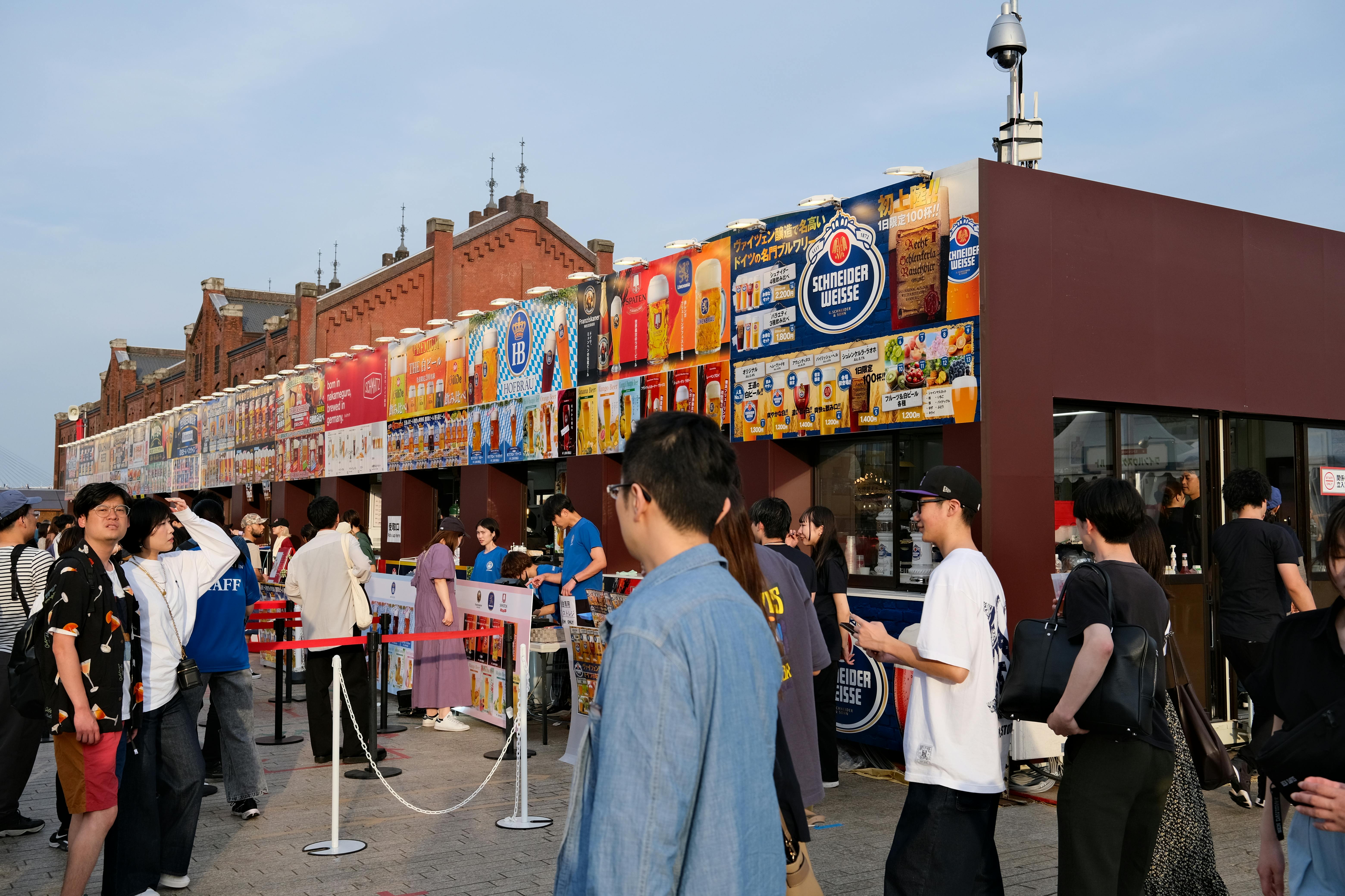 Crowds enjoy a festival at the Yokohama Red Brick Warehouse with vibrant displays and food stalls.