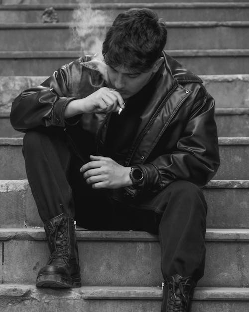 A man smoking on the steps of a building