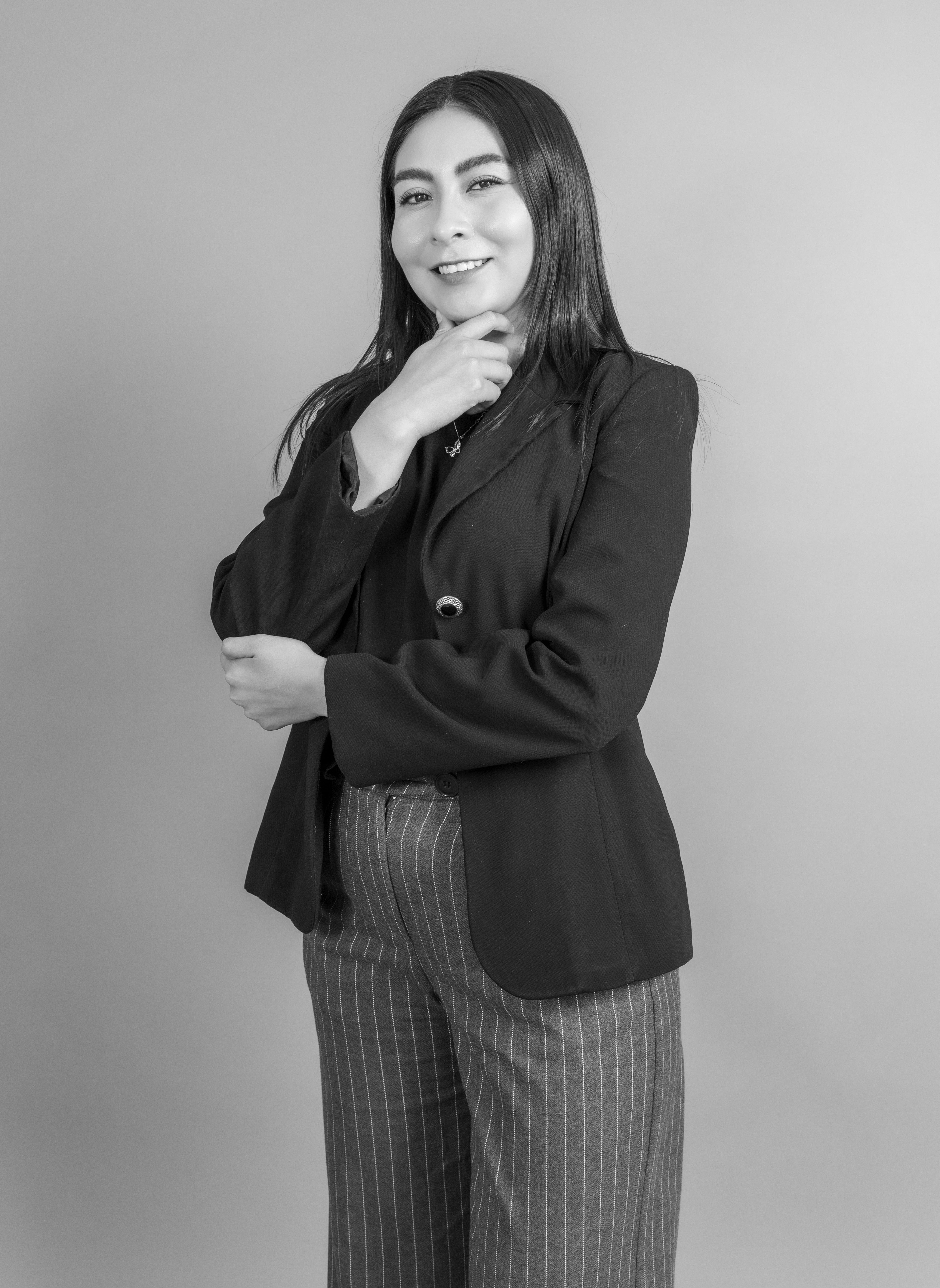 Stylish black and white portrait of a smiling woman posing confidently in a blazer.