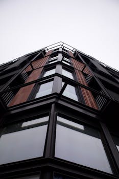 Low angle view of a modern urban building with geometric design and large windows.