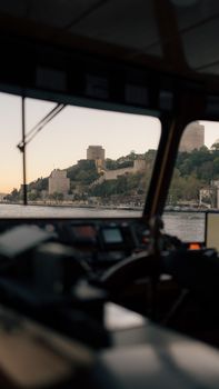 A glimpse of the historic Rumeli Fortress from inside a ferry on the Bosphorus Strait at sunset.