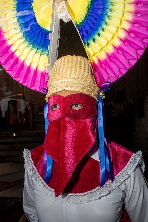 A man wearing a mask and colorful hat