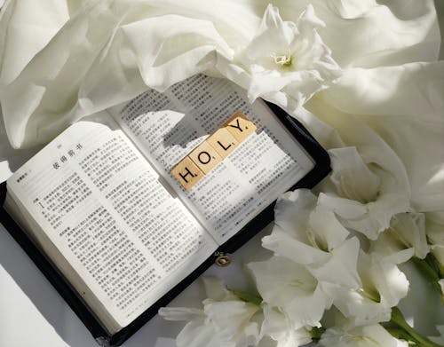 A bible with flowers and a white sheet