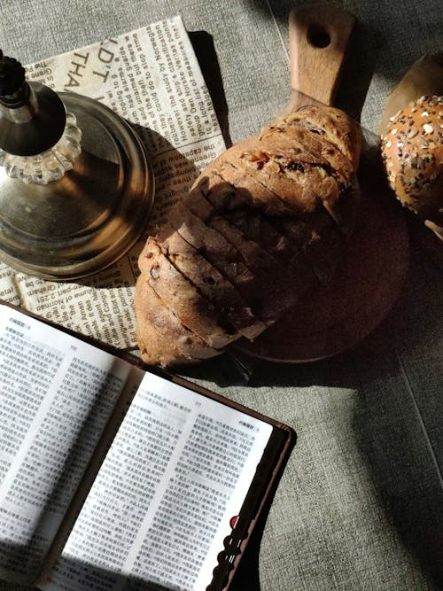 A bible, bread and a candle sit on a table