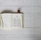 An open bible on a white wooden table