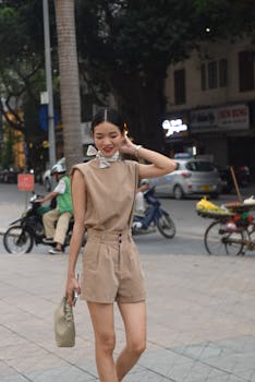 Stylish woman posing on a city street wearing fashionable beige attire, showcasing urban fashion.