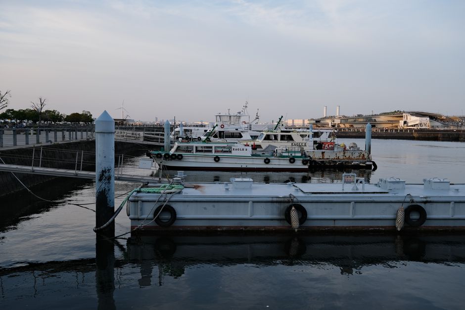 Serene view of boats moored at the pier in Yokohama, Japan during dusk.