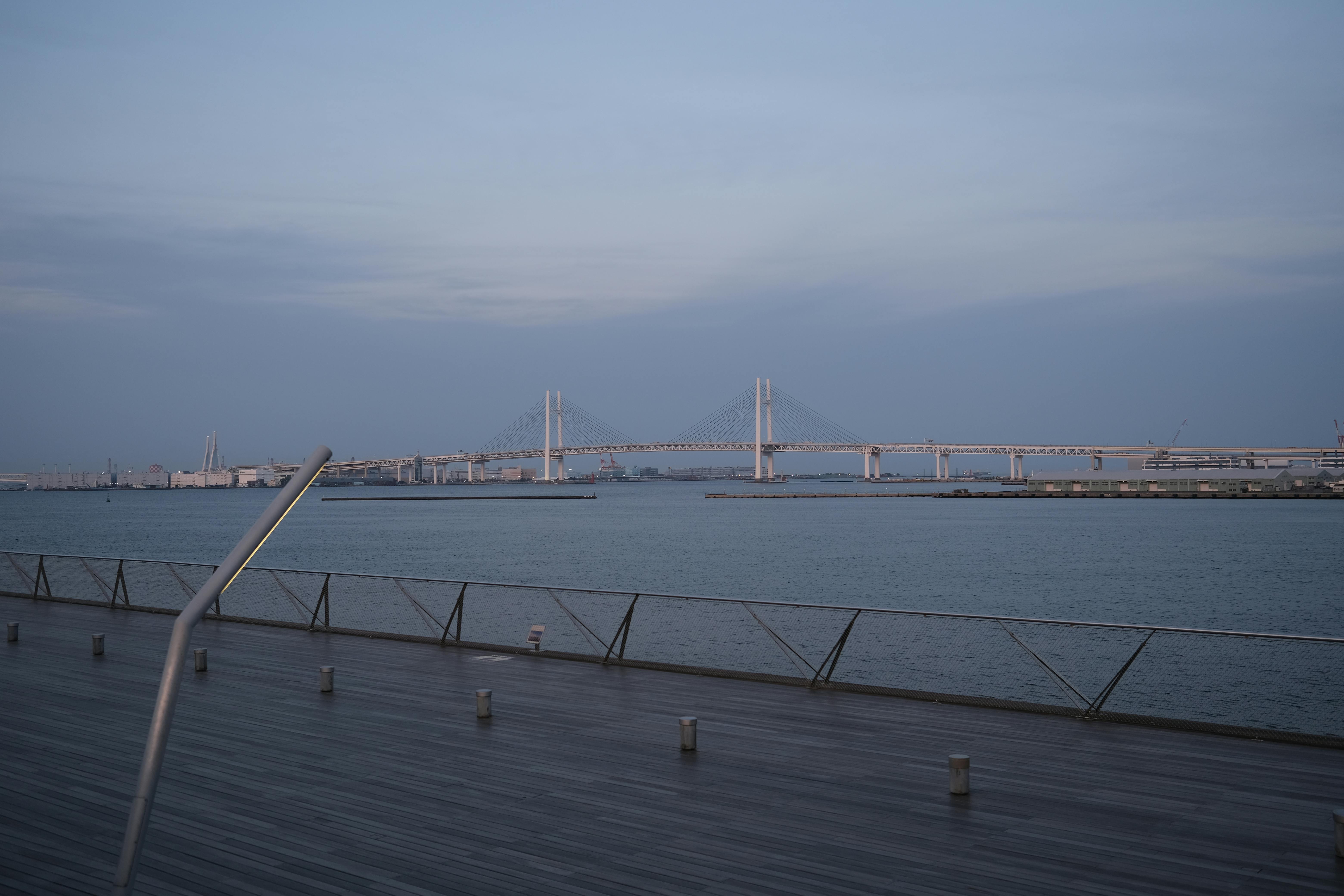 Calm and peaceful view of Yokohama Bay Bridge during twilight, highlighting urban architecture.