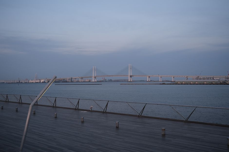 Calm and peaceful view of Yokohama Bay Bridge during twilight, highlighting urban architecture.
