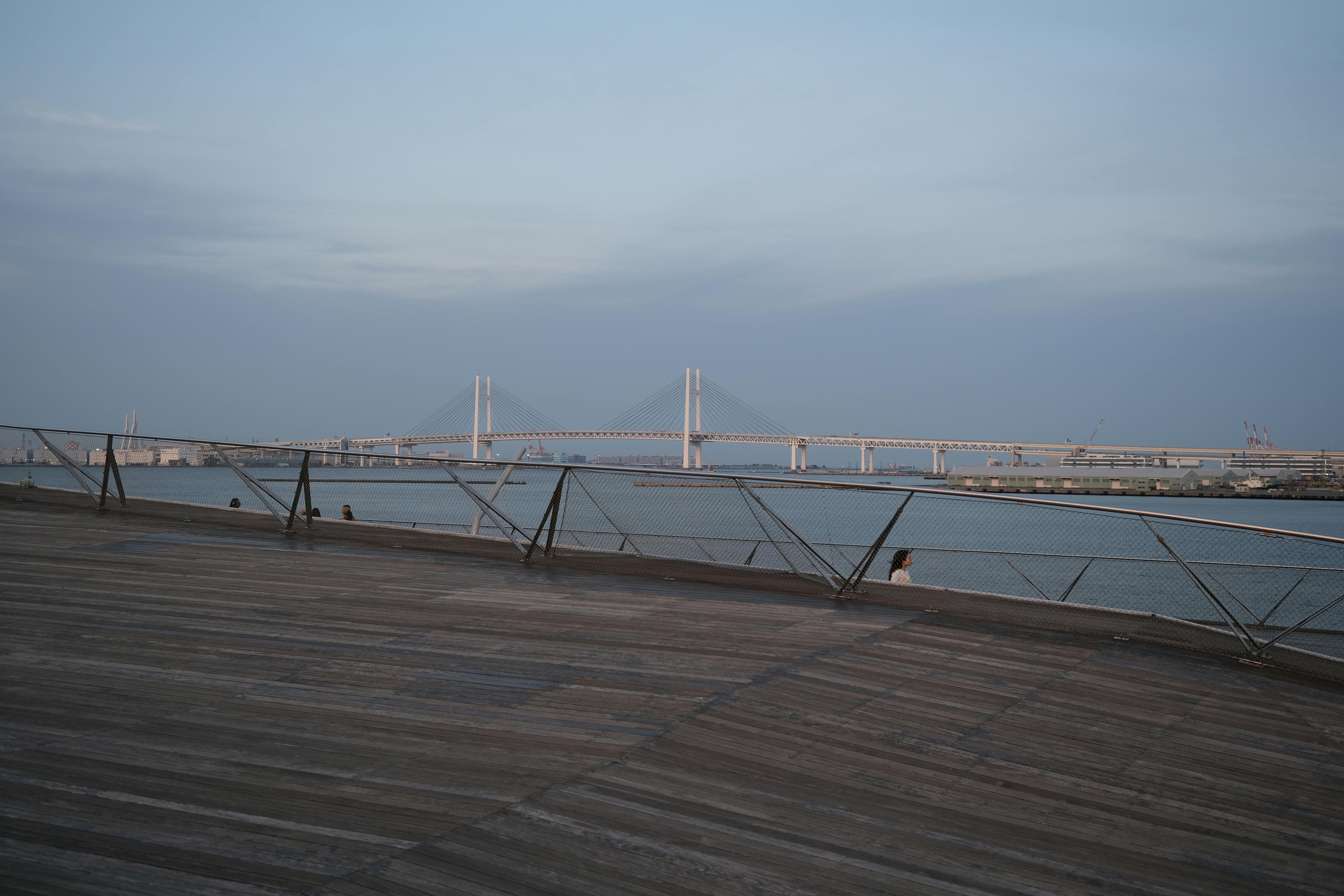 Serene view of Yokohama Bay Bridge at dusk with modern architecture and waterfront.