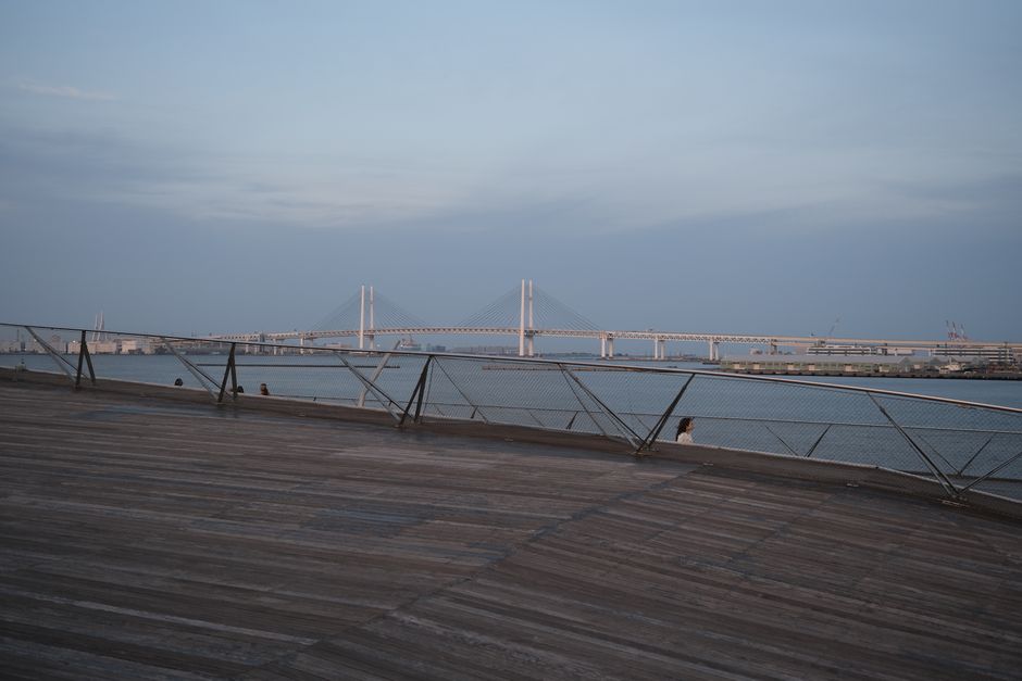 Serene view of Yokohama Bay Bridge at dusk with modern architecture and waterfront.