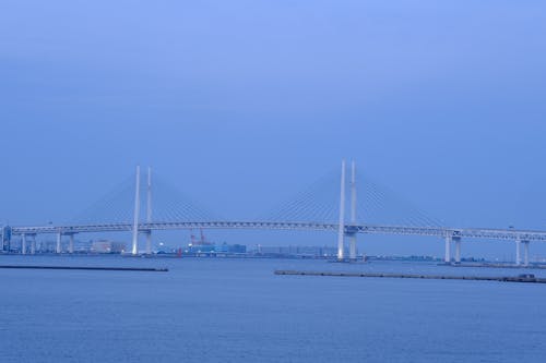 A bridge over the water with a large ship in the background