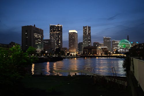 A city skyline at night with a river in the background