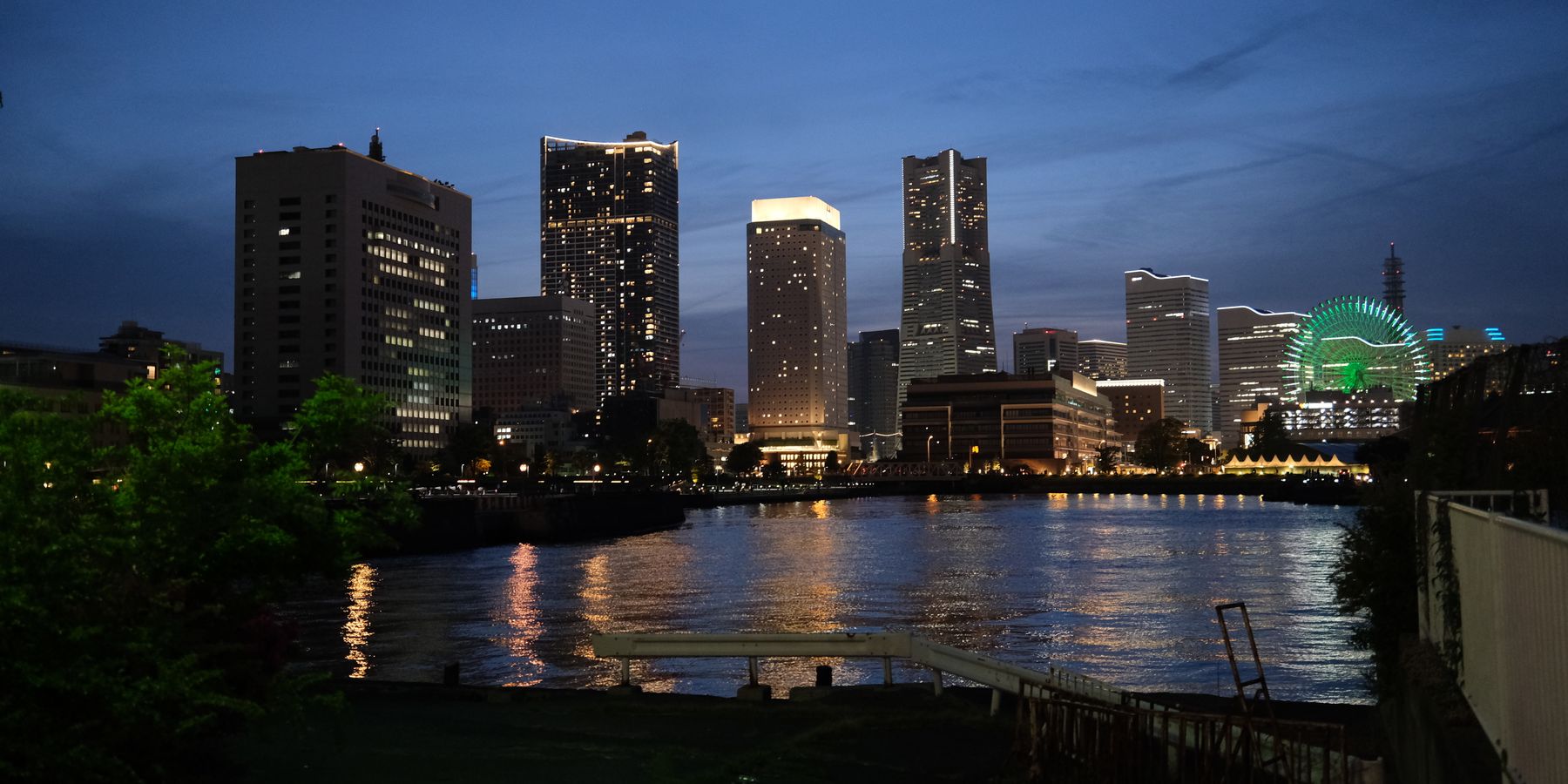 Beautiful view of Yokohama city lights reflecting on the water during twilight.