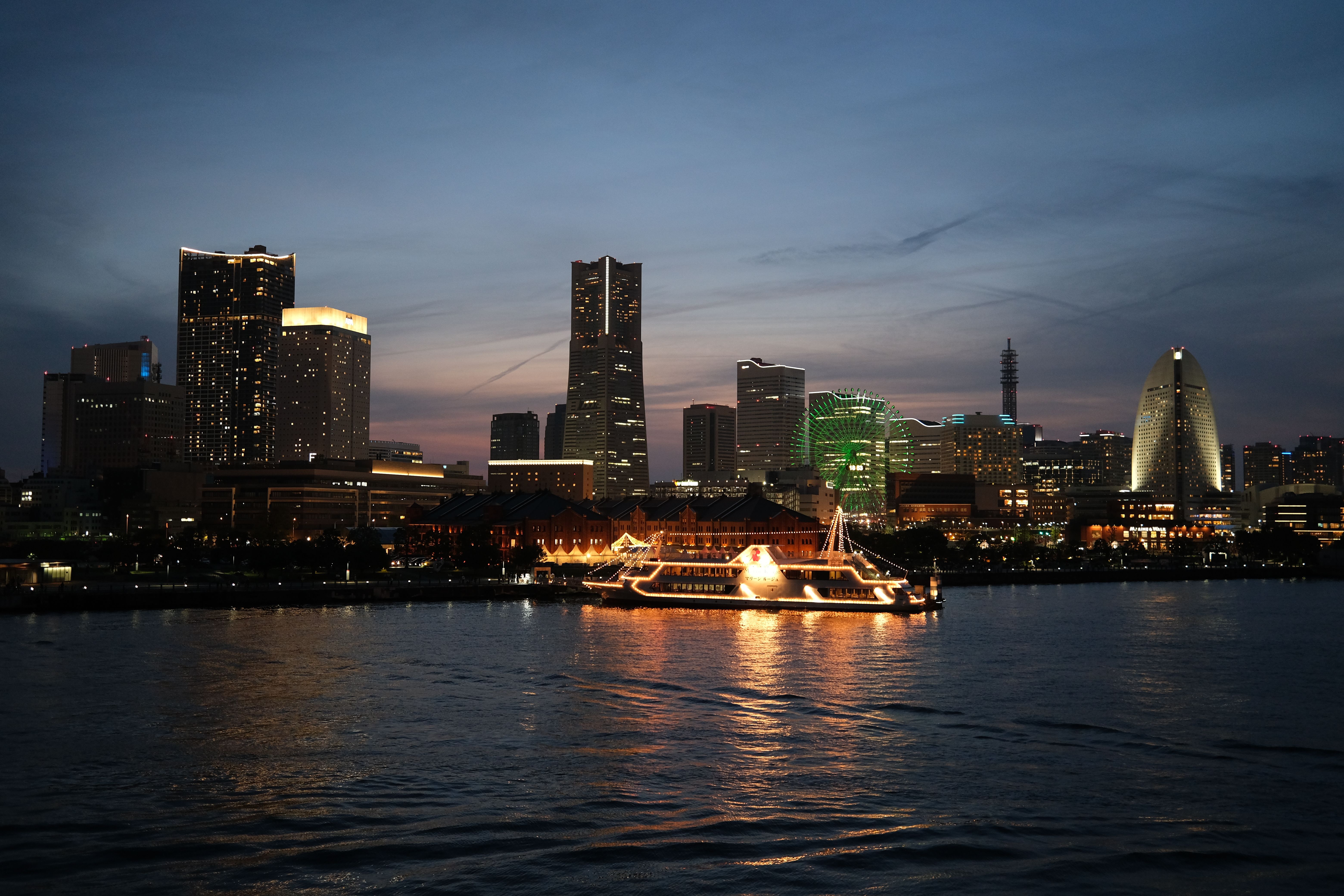 Explore the vibrant Yokohama skyline at dusk, showcasing illuminated landmarks and waterfront reflections.