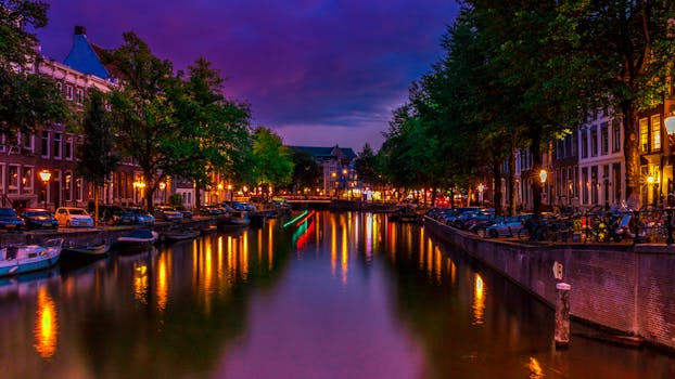 阿姆斯特丹运河的夜色充满活力，倒影与城市灯光丰富多彩