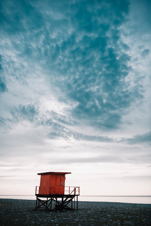 Free Red and Black Cottage by the Seashore Stock Photo