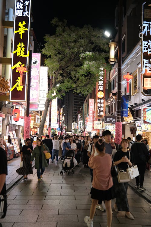 People walk down a busy street at night