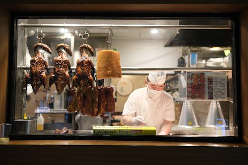 A chef is preparing food in a window
