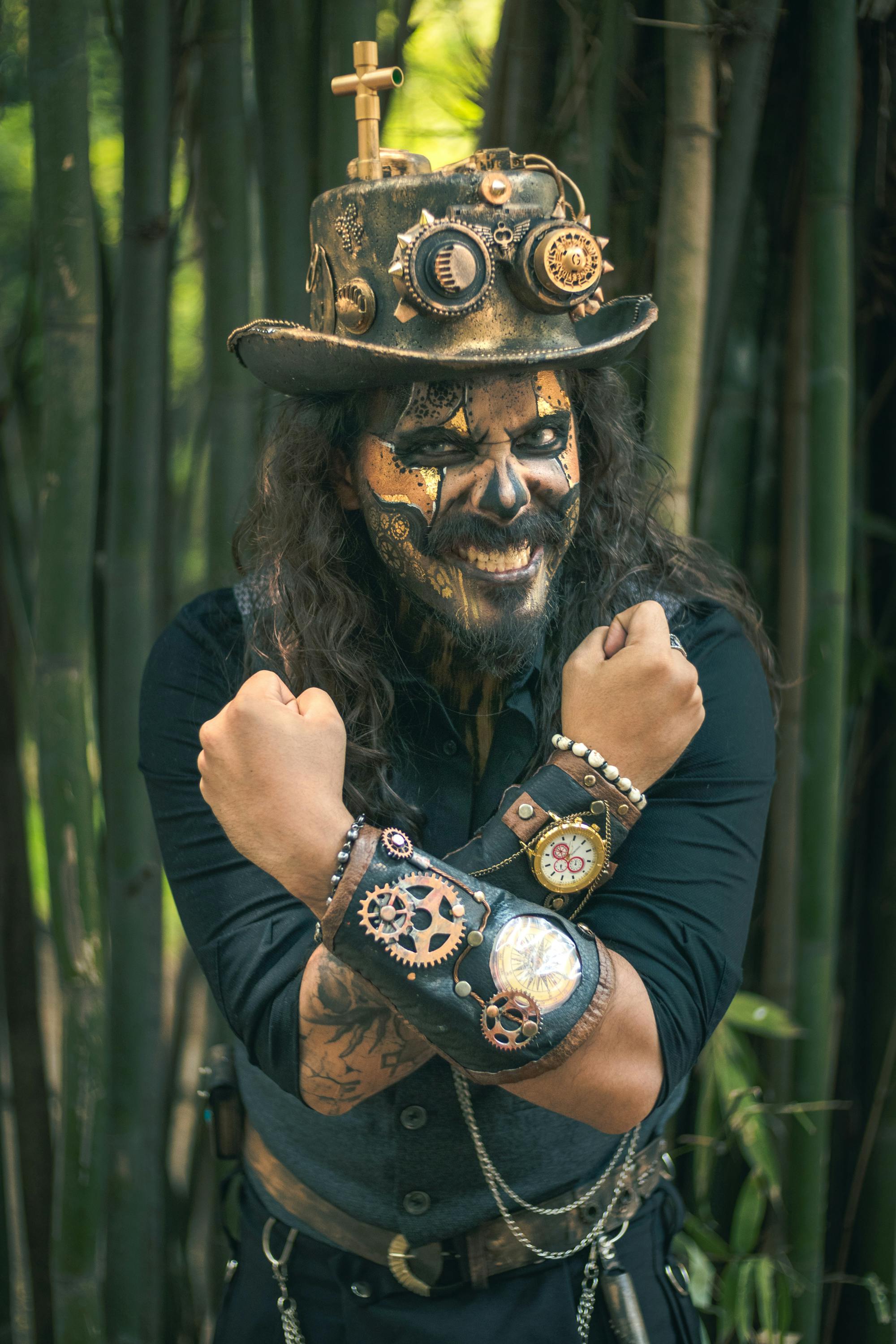 Free A steampunk enthusiast in detailed costume poses with arms crossed against a bamboo forest backdrop. Stock Photo