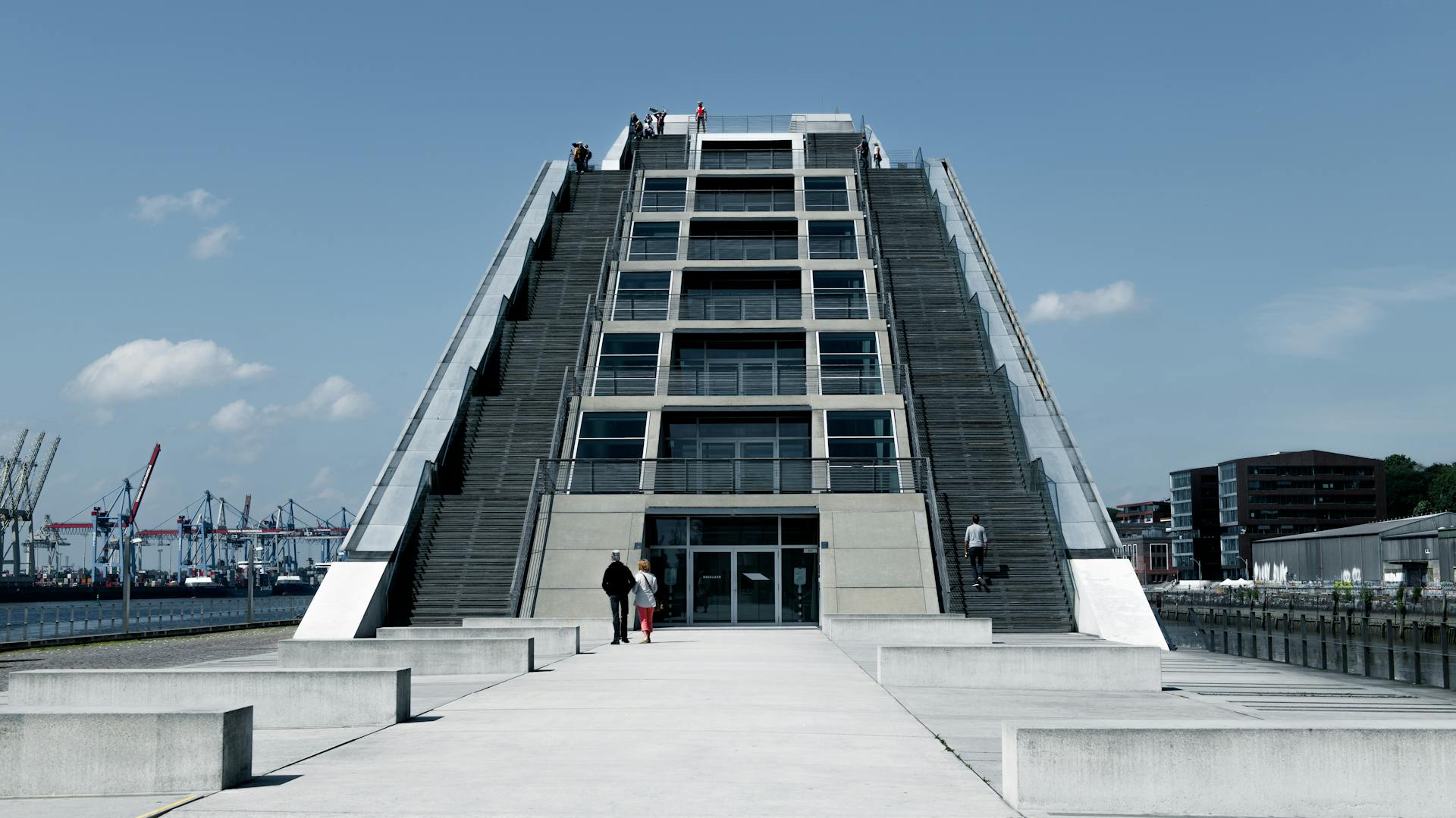 Modern architectural design of Hamburg's Dockland building, featuring unique escalated structure and waterfront view.
