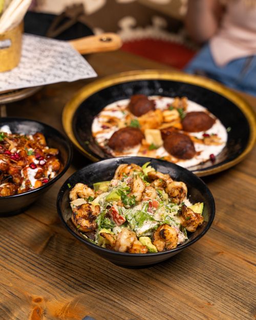 Free A vibrant and appetizing Middle Eastern mezze spread featuring fresh shrimp, meatballs, and chickpea dishes in rustic bowls. Stock Photo