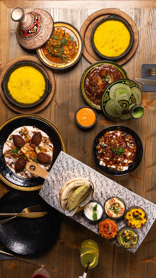 A table with plates of food and bowls of food