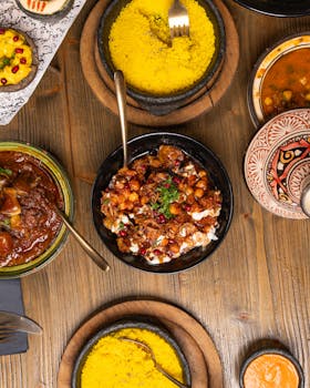 Top view of Middle Eastern dishes including rice, stew, and salads on a rustic wooden table.