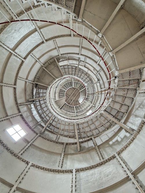 A spiral staircase inside a building with a white ceiling