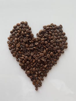 A heart shape made from coffee beans on a white background, symbolizing love for coffee.