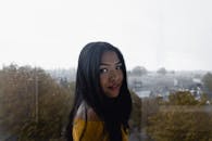 一位女士在窗前雨中摆姿的迷人肖像，展现了宁静与美丽