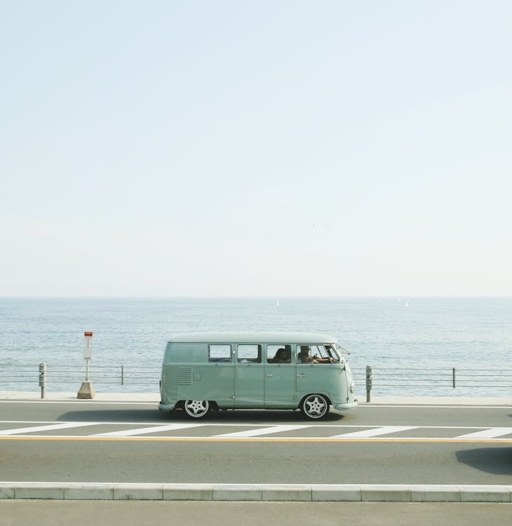 Free Van Parked Beside the Road Near Handrail and Ocean Stock Photo