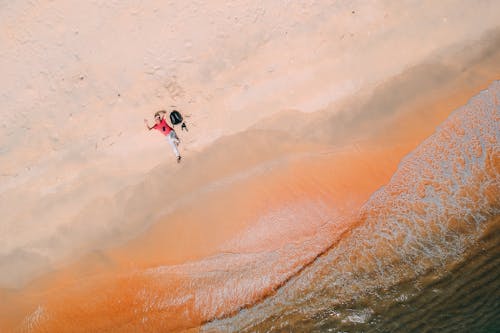 Free Person Lying Down on Sand Stock Photo