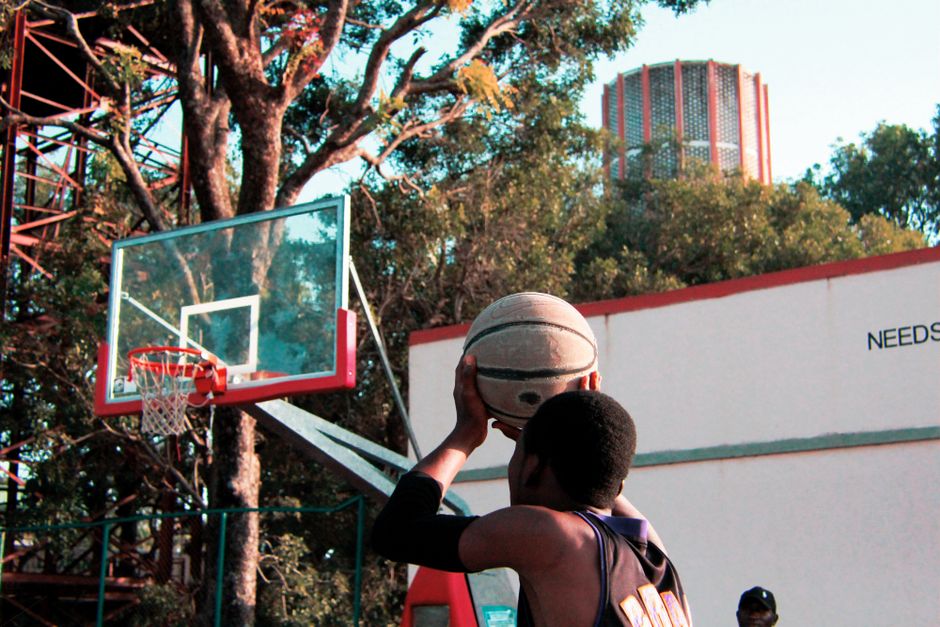 A young player aims to score on an outdoor basketball court, capturing the essence of sport and determination.