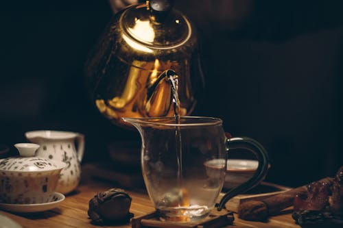 бесплатная Золотой стальной чайник рядом с прозрачным стеклянным кувшином Стоковое фото