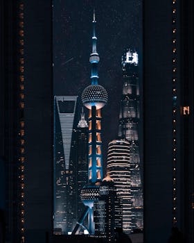 Futuristic skyscrapers of Shanghai illuminated at night, showcasing modern architectural marvels.