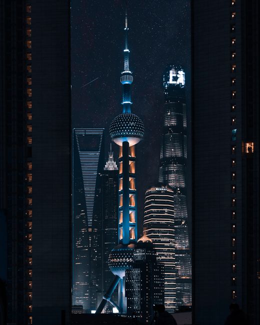 Futuristic skyscrapers of Shanghai illuminated at night, showcasing modern architectural marvels.