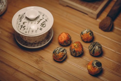 Free Stylish Chinese tea set with blooming tea balls on bamboo surface, capturing serene tea culture. Stock Photo