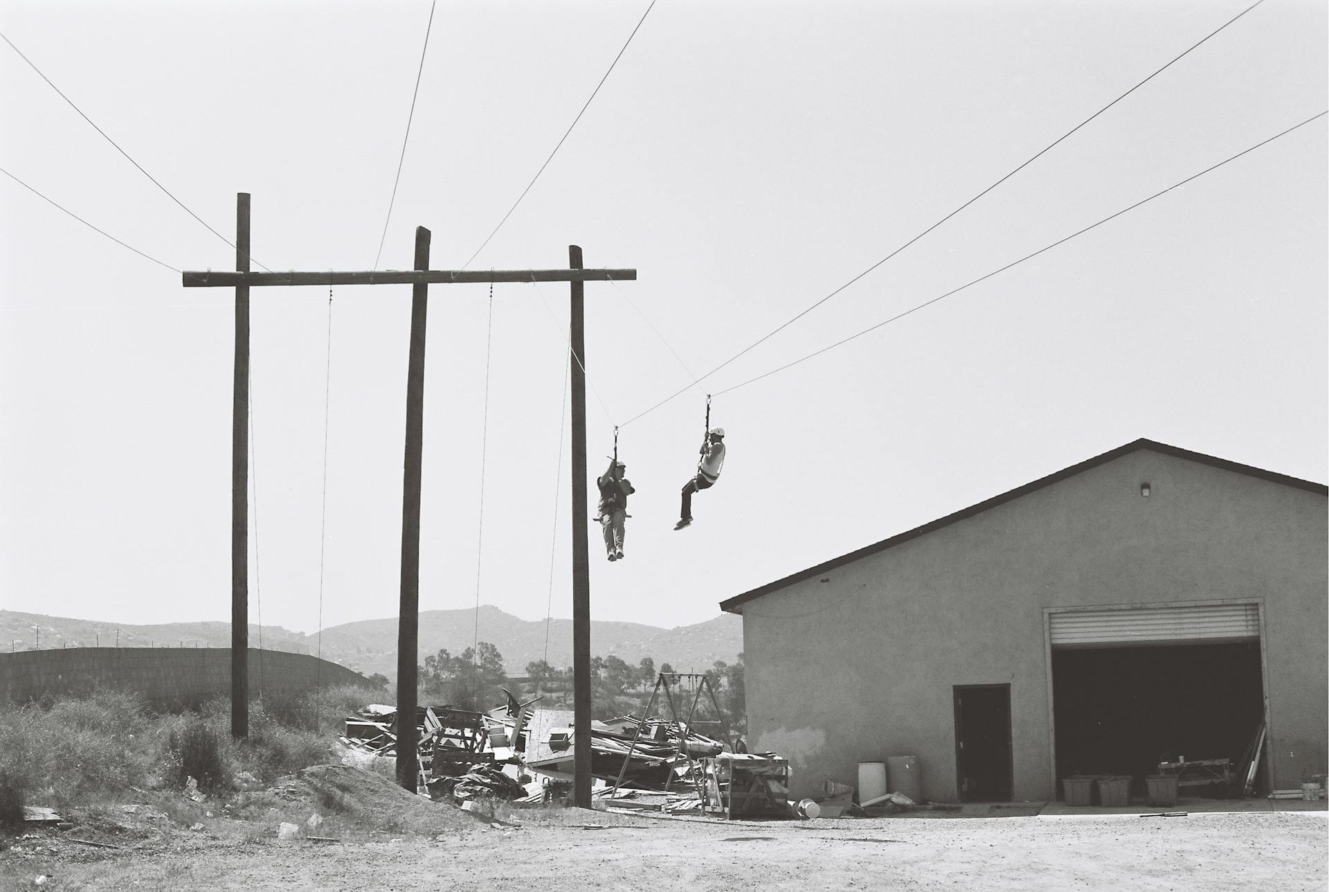 Two Persons Working On Electric Cables Near Building