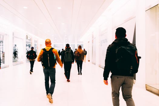 Group of travelers walking through a bright, modern airport terminal carrying backpacks.