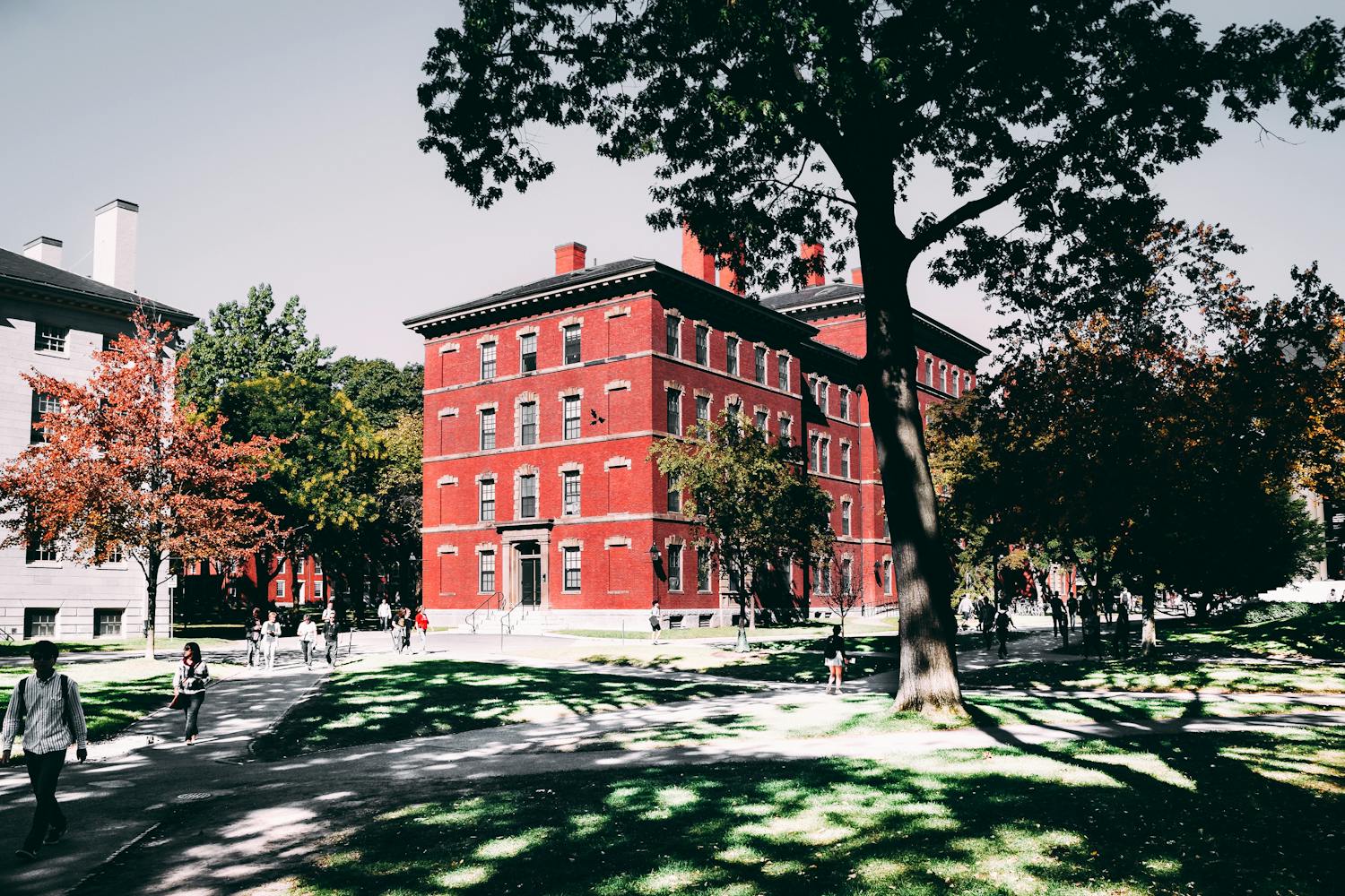 Historic red brick university building surrounded by lush trees