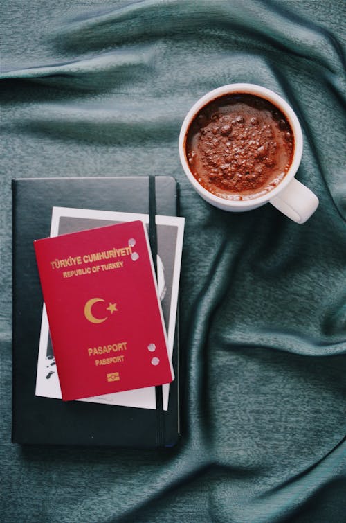 White Ceramic Mug and a passport and a book