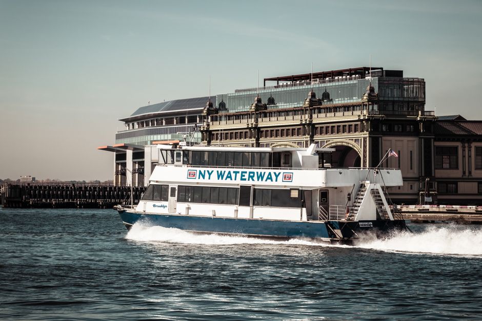 Amazing New York City Christmas Holiday Lights Sightseeing Cruise Review: A Magical Night on the Hudson Review 2026 - NY Waterway ferry sailing past a historic building in New York Harbor, showcasing nautical transit.