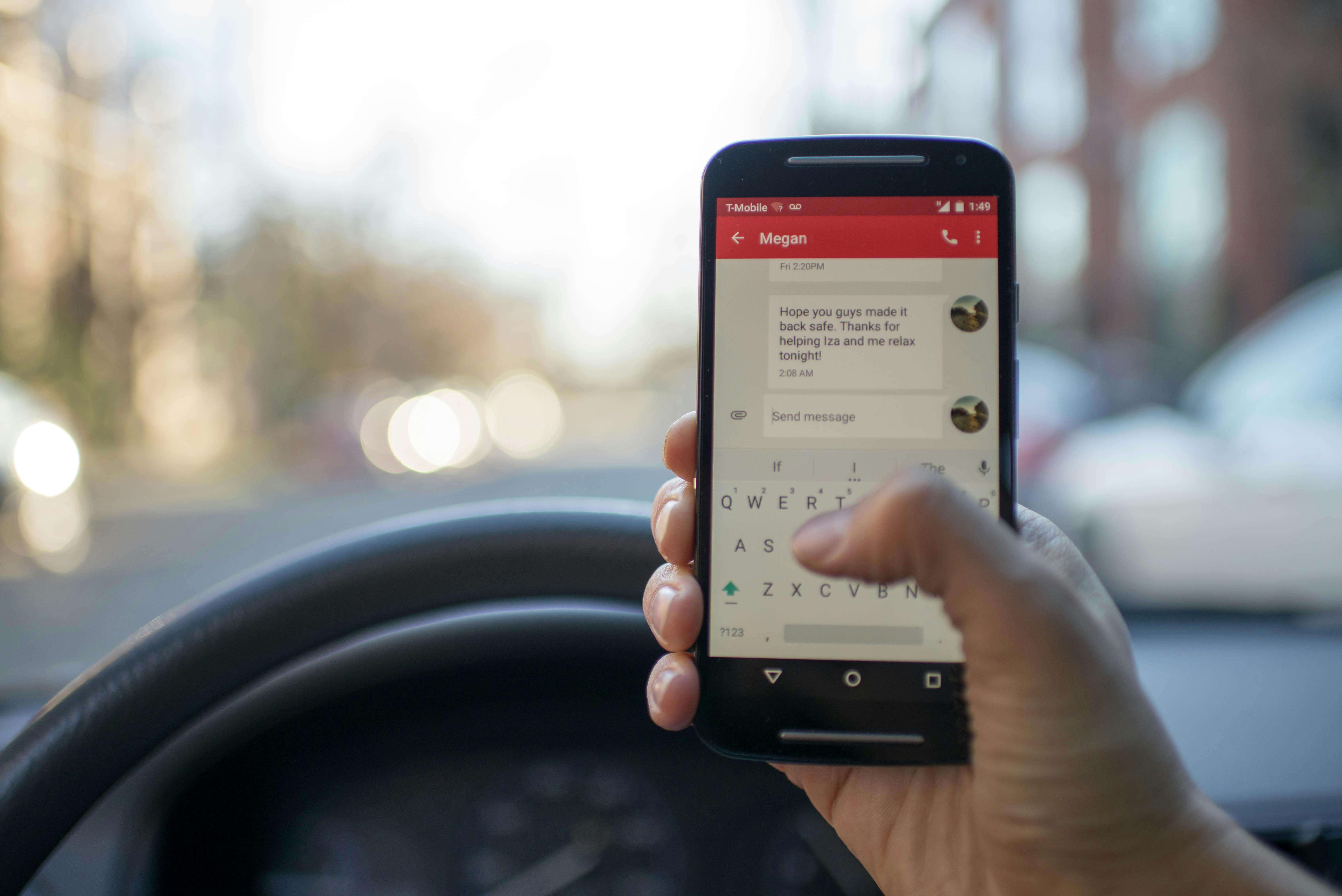 person sitting inside car with black android smartphone turned on