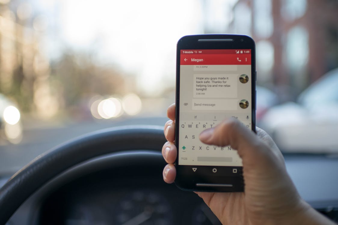 Person Sitting Inside Car With Black Android Smartphone Turned on