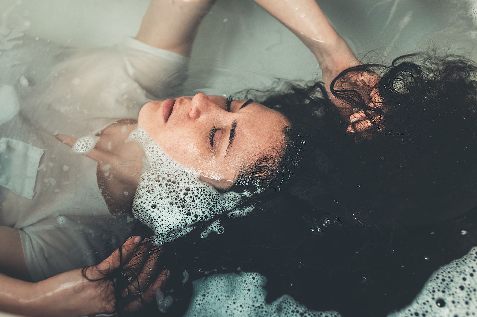 Woman sitting in an ice bath, practicing cold therapy for muscle recovery.